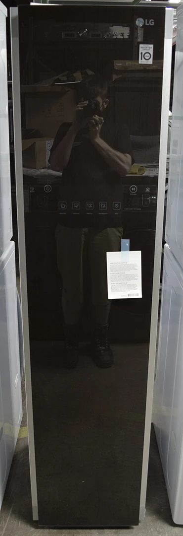 A close-up of a brand new LG Styler S3RFBN Steam Clothing Care System with TrueSteam front door, with the photographer's reflection visible on the door frame.