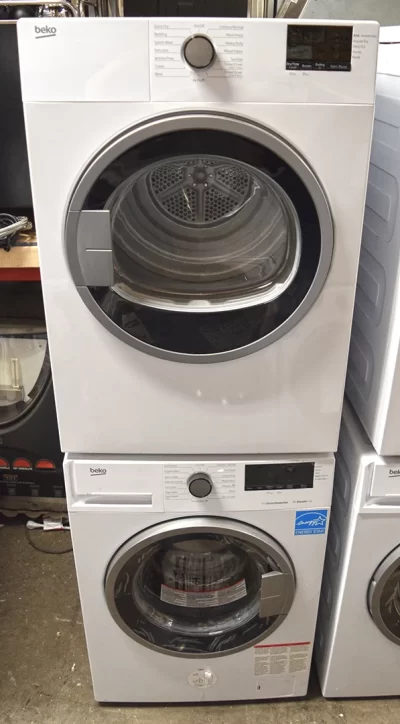 A close-up of the front view of a white Beko BDV7200X 24-inch electric dryer and BWM7200X front-load washer.